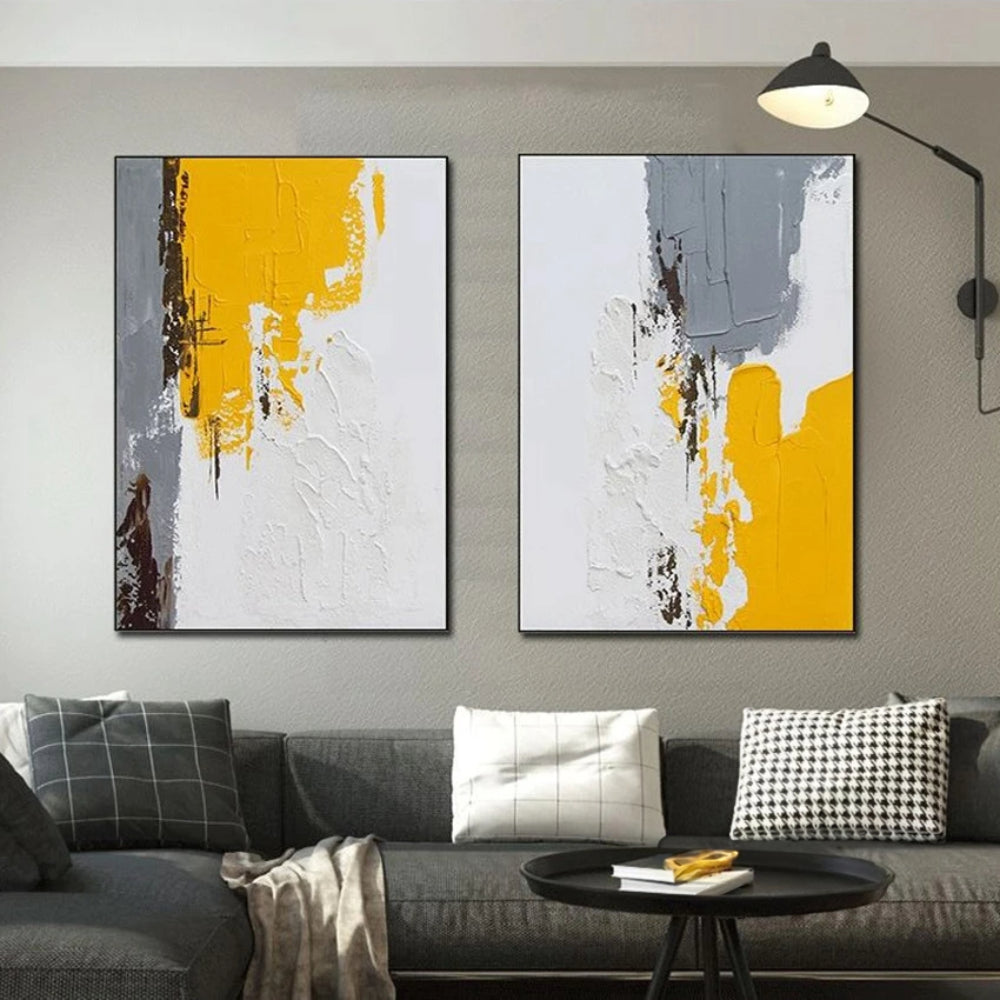 Room mockup showing pair of white textured abstracts with mustard yellow and grey blocks and small dark brown marks.