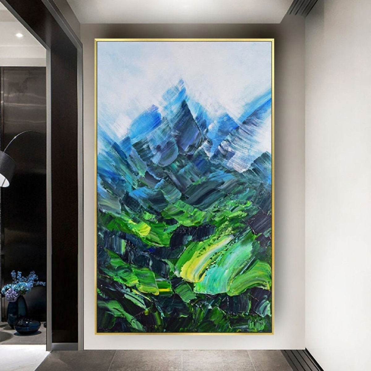 Room mockup. Angular blue mountain peaks rise above a vivid green valley with sweeping textured green and turquoise strokes.