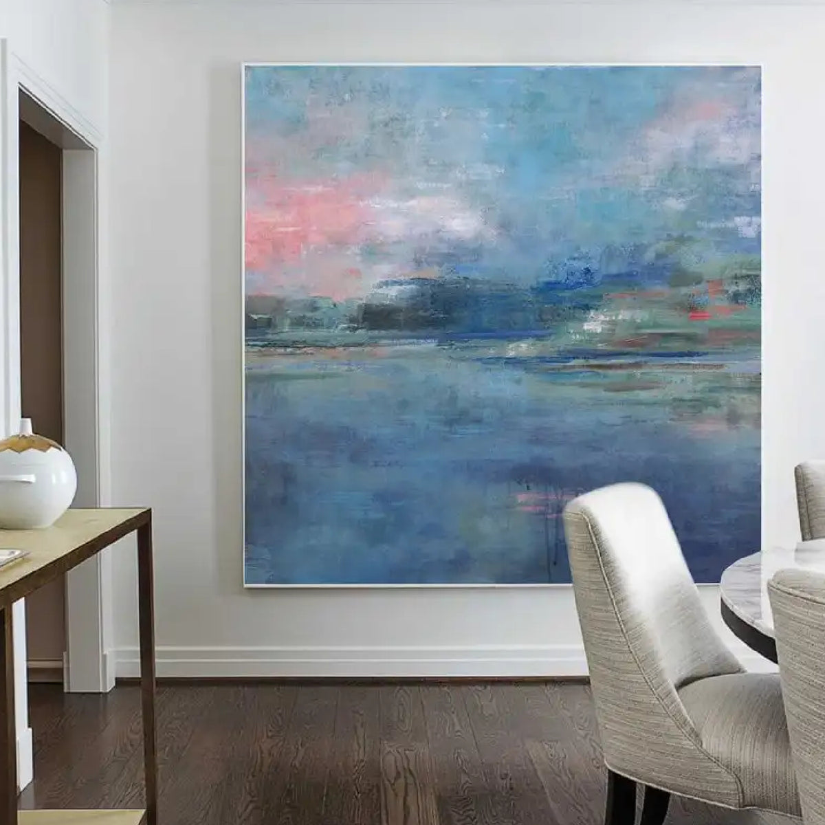 Room mockup showing soft blue water-like fields beneath pink and blue clouds, with a distant green and dark blue horizon.