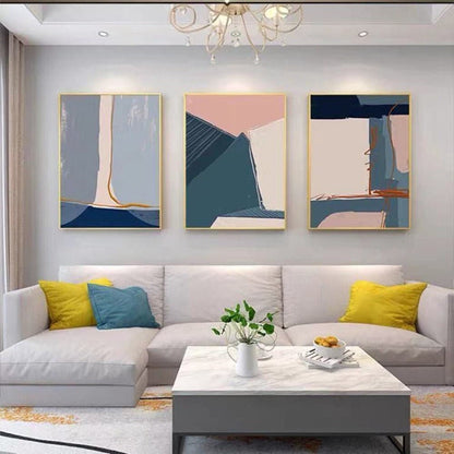 Room mockup. Three-panel abstract artwork with slate blue, pink and cream angular fields edged by gold-coloured lines.