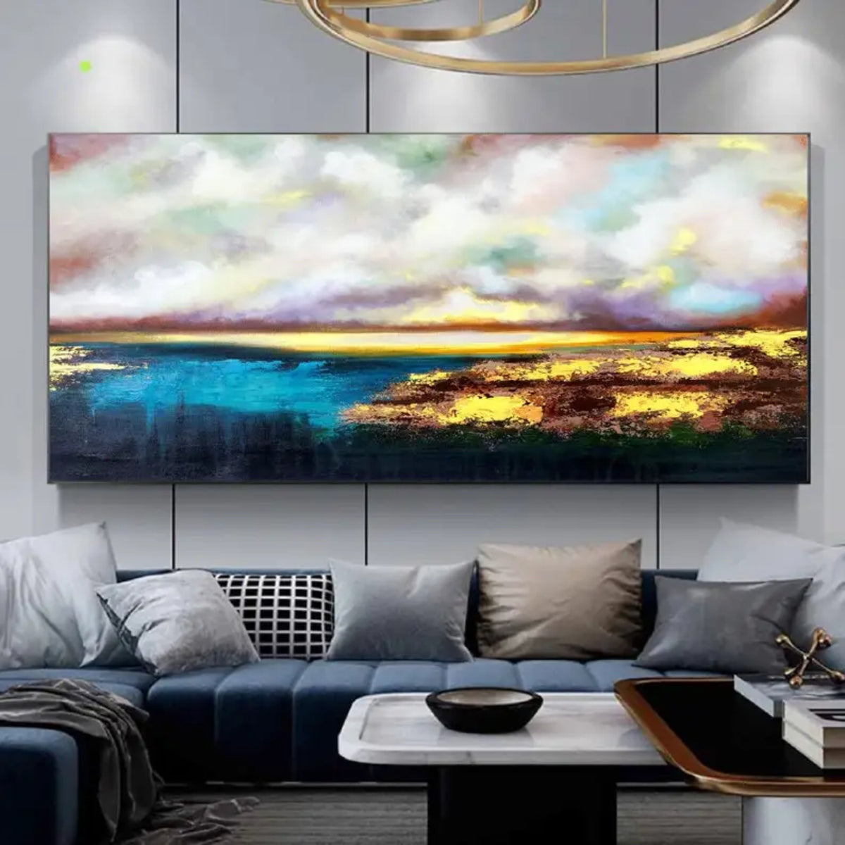 Room mockup showing gold-coloured light reflected on dark blue water beneath broad white, grey and muted pink clouds.