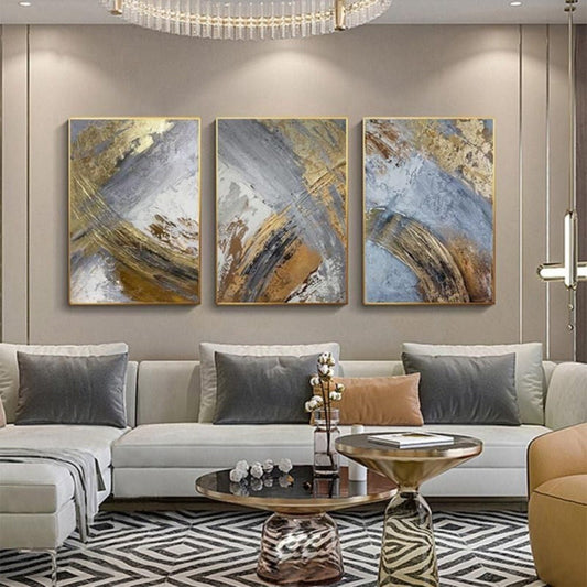 Room mockup. Three complementary panels with broad grey diagonal strokes, gold-coloured textured sweeps and white and brown patches.