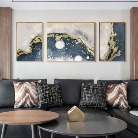 Room mockup. Three-panel abstract artwork with flowing navy and cream fields, gold-coloured borders and white circles.