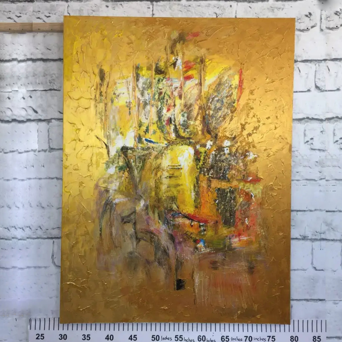 Room mockup. An ochre and yellow textured field with a dense central cluster of grey, cream, rust and dark scraped marks.