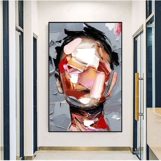 Room mockup. A man’s face built from angular pink, cream, orange and brown strokes, with black hair against a grey background.