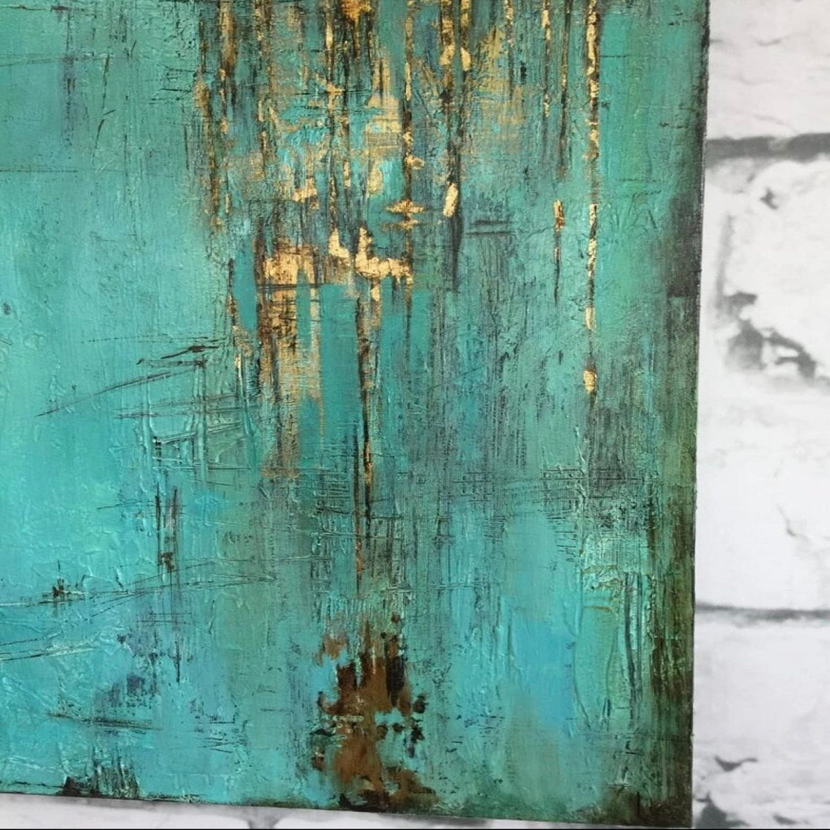 Close-up. A turquoise textured field with fine dark scratched marks and gold-coloured patches dripping down from an upper edge.