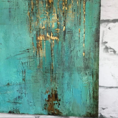Close-up. A turquoise textured field with fine dark scratched marks and gold-coloured patches dripping down from an upper edge.