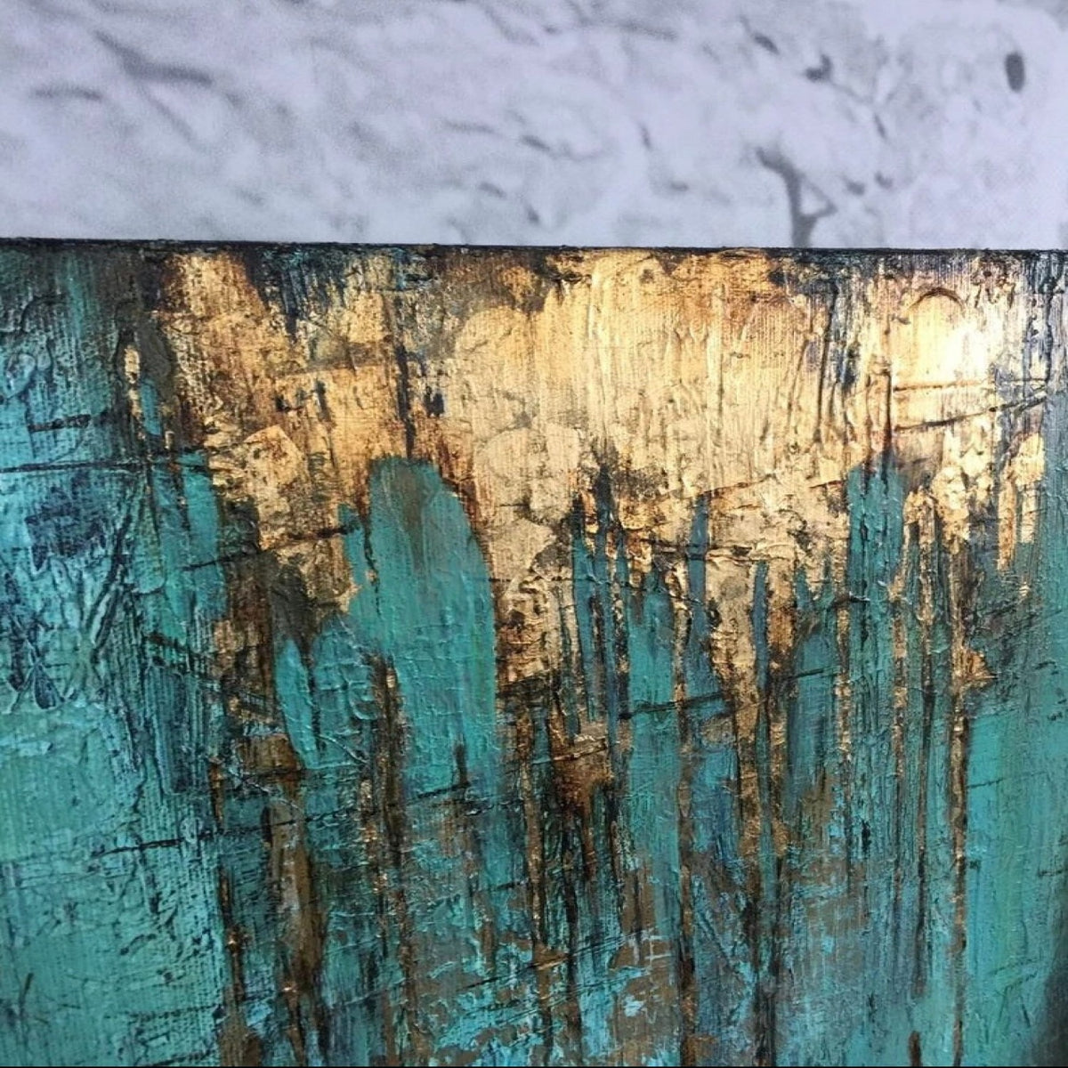 Close-up. A turquoise textured field with fine dark scratched marks and gold-coloured patches dripping down from an upper edge.