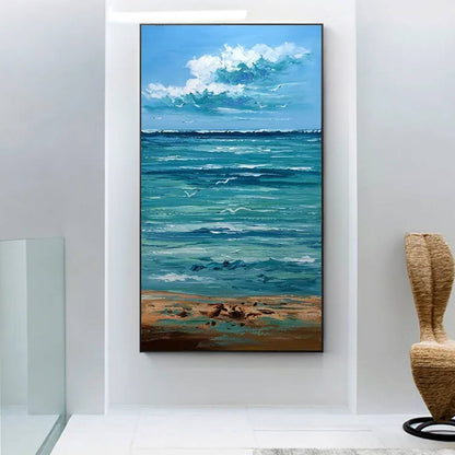 Room mockup. White cloud clusters above a turquoise sea with pale rippling waves, a sandy shore and small dark shorebirds.