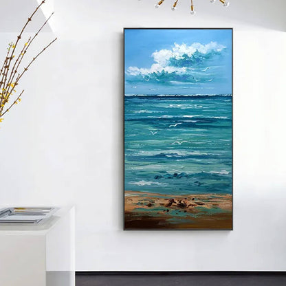 Room mockup. White cloud clusters above a turquoise sea with pale rippling waves, a sandy shore and small dark shorebirds.